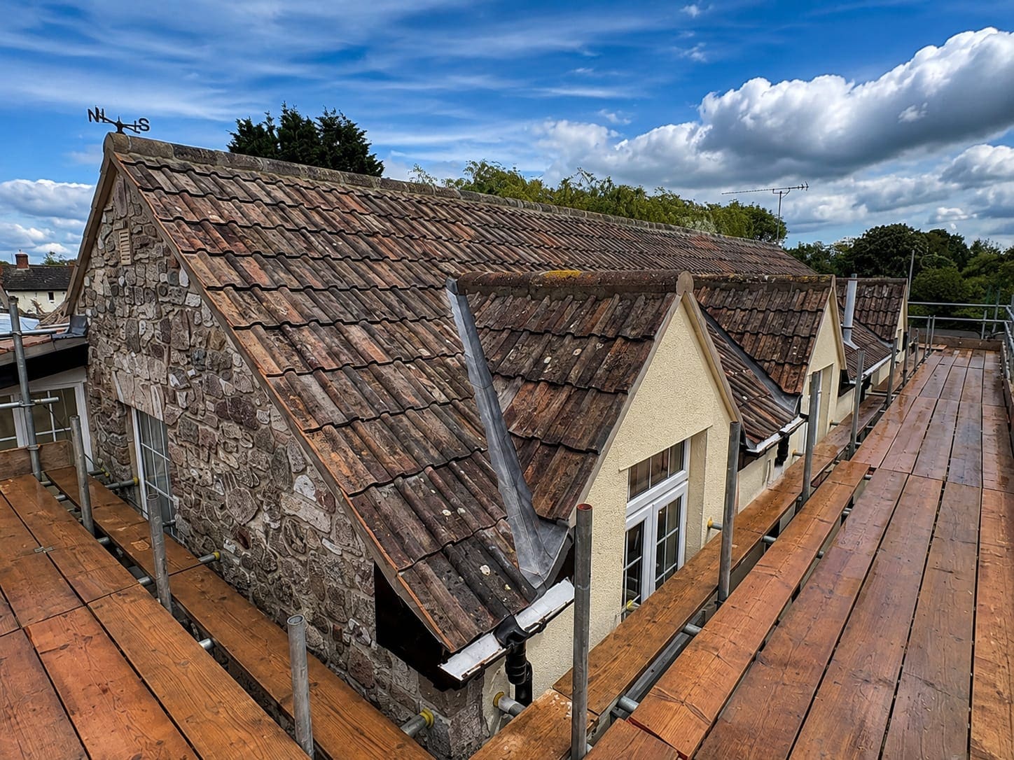 Tiled roof and dormers seen from the scaffold during a roof renewal