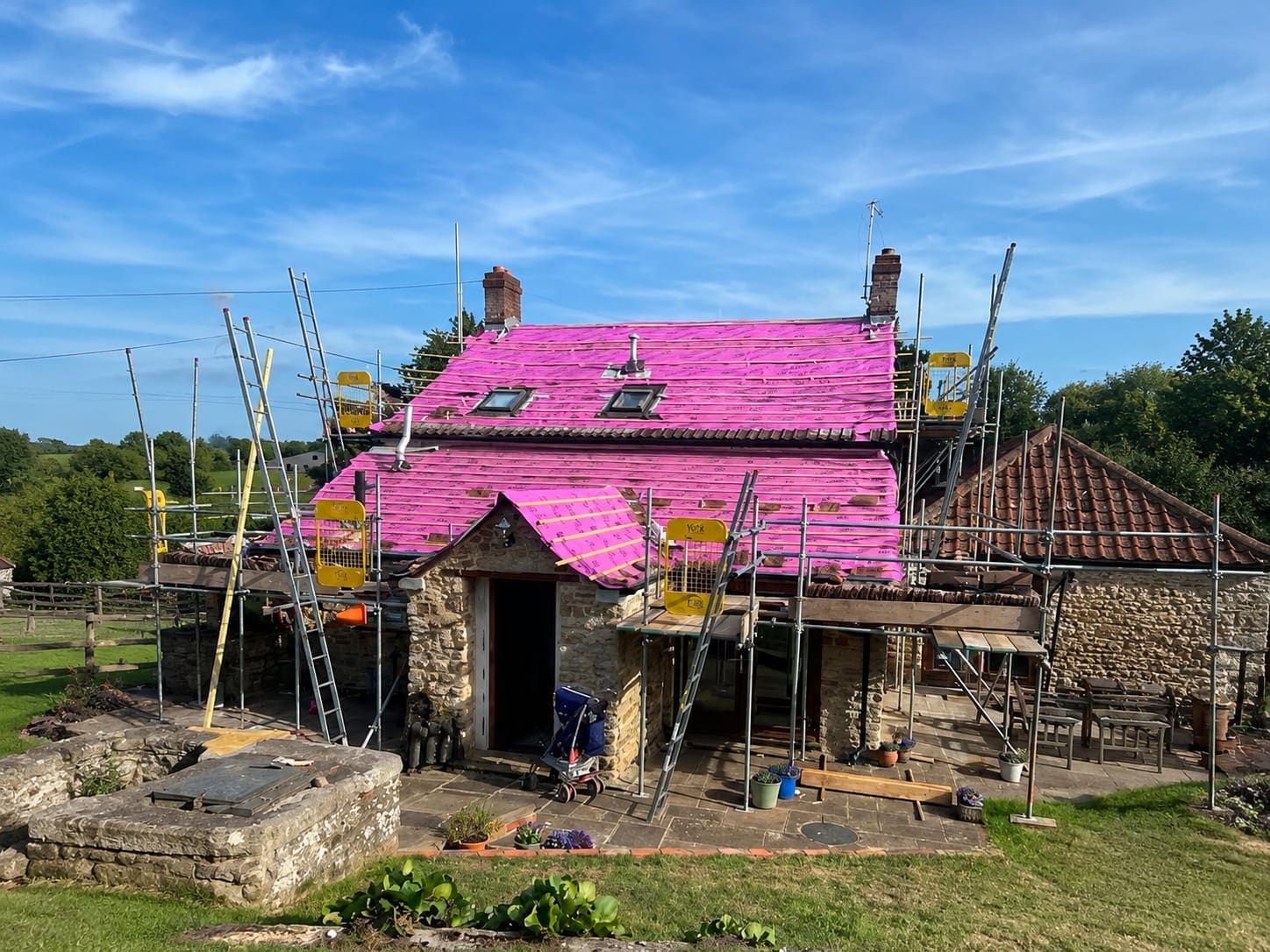 Roof stripped back to the battens and breather membrane, with scaffold around the property